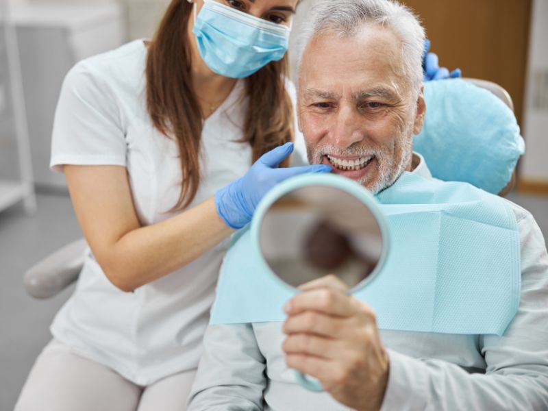 A patient admiring their dental implants for seniors in Lancaster, TX
